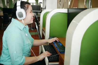 Blinde Frau mit Hilfsmittel an Computer