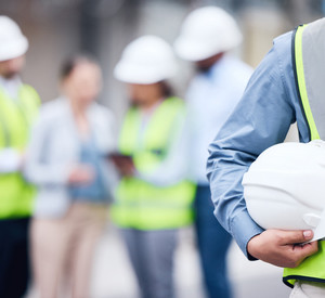 Aufnahme eines unkenntlichen Architekten mit Helm auf einer Baustelle